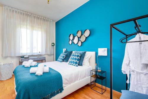 a blue bedroom with a bed and a blue wall at Art Deco' - Sleepwithme - Free Parking - Free Breakfast - Very Friendly Staff in Pisa