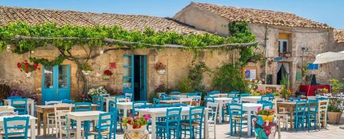 a group of tables and chairs in front of a building at Casa Vacanze Matilde Marzamemi in Marzamemi