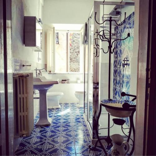 ein Badezimmer mit einem blauen und weißen Fliesenboden in der Unterkunft Casa Pizzinelli in San Casciano dei Bagni