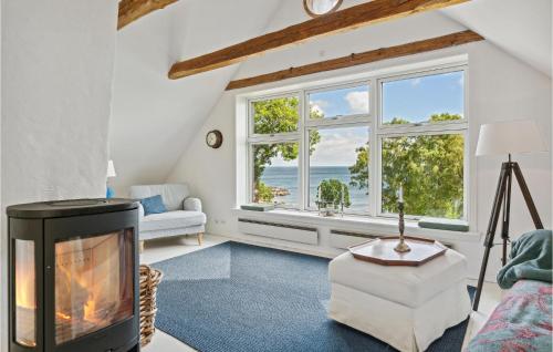 d'un salon avec une cheminée et une vue sur l'océan. dans l'établissement Amazing Apartment In Svaneke With Wifi And 2 Bedrooms, à Svaneke