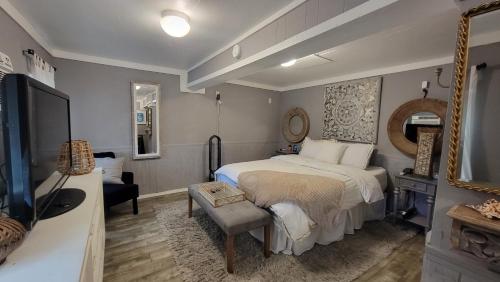 a bedroom with a bed and a chair and a mirror at Sea-La-Vie, your beach house oasis in Freeport