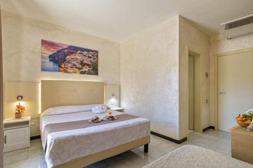 a bedroom with a bed and a painting on the wall at HOTEL CRISTALLO PAESTUM in Capaccio-Paestum