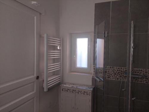 La salle de bains est pourvue d'une douche et d'une fenêtre. dans l'établissement Le Petit Mas des Alpilles en Provence, à Saint-Étienne-du-Grès