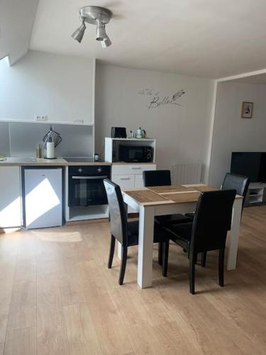 a kitchen with a table and chairs in a room at Duplex très charmant in Melun