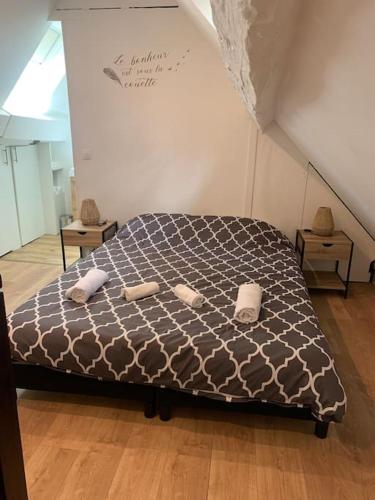 a bedroom with a bed with two towels on it at Duplex très charmant in Melun