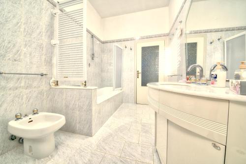 a white bathroom with a sink and a toilet at la Casa del Vino - B&B in Tollo