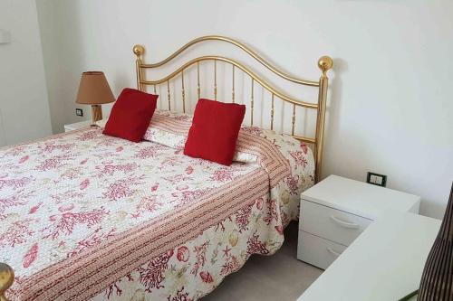 ein Schlafzimmer mit einem Bett mit zwei roten Kissen in der Unterkunft DOMUS BARONE in Spongano