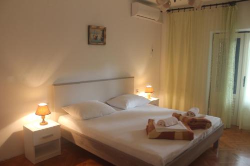 ein Schlafzimmer mit einem Bett mit zwei Handtüchern und zwei Lampen in der Unterkunft Apartment Jure in Senj