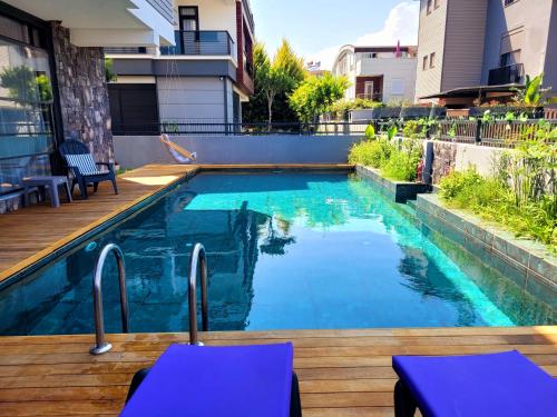 a swimming pool with blue water in a backyard at OLDSKOOL TOWN HOUSES 15 minutes walk to LARA beach in Lara