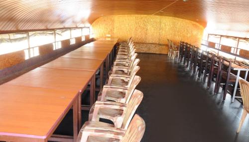 a row of tables and chairs in a room at Beach Paradise Day Cruise Houseboat in Alleppey