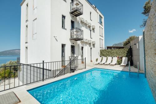 an apartment with a swimming pool in front of a building at SkyView apartments in Herceg-Novi
