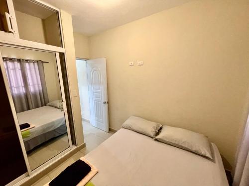 um pequeno quarto com um espelho e uma cama em Oasis de Paz 1.2 em Jarabacoa