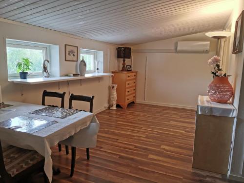 a dining room with a table and a kitchen at Tofta Konstgalleri-Hel Lägenhet 70kvm in Varberg