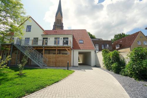 a house with a steeple in the background at Ferienwohnung Schlei-Suite in Schleswig