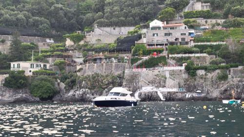 a boat in a body of water with houses at Amalfi Coast Yacht in Minori