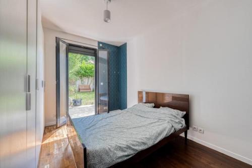 une chambre avec un lit et une porte coulissante en verre dans l'établissement Maison au calme à 10 minutes à pied du métro ligne 11, à Romainville