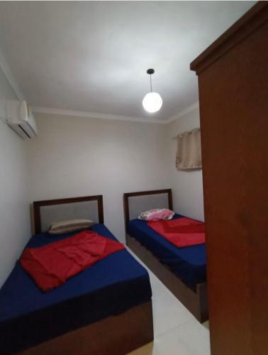 two beds in a small room with a light at الحدائق المعلقة المصطبة الخامسة بورتو السخنة للعائلات فقط in Ain Sokhna