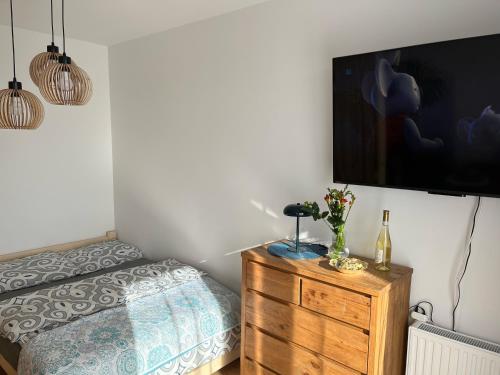 a bedroom with a bed and a tv on a wall at Apartament Stogi in Gdańsk