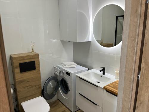 a bathroom with a washing machine and a sink at Apartament Stogi in Gdańsk