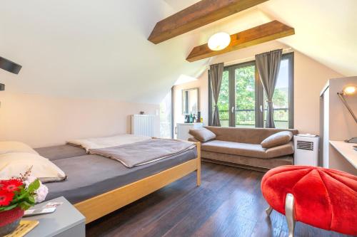 een kleine slaapkamer met een bed en een bank bij BnB Comfort Guesthouse Olten - Lostorf in Lostorf