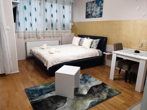 Dormitorio pequeño con cama y mesa en Aurora 2, en Novi Sad