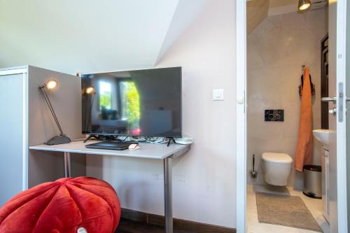 a small room with a desk and a toilet at BnB Comfort Guesthouse Olten - Lostorf in Lostorf