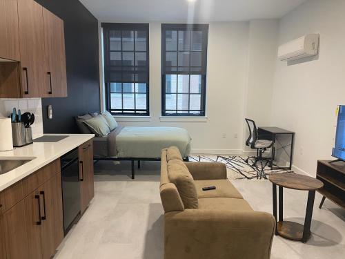 een keuken en een woonkamer met een bank en een bed bij Hartford Downtown: 2mins walk to XL Center in Hartford