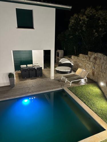 une piscine devant une maison la nuit dans l'établissement maison avec piscine, à Guéthary