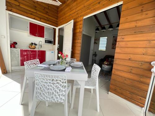 y cocina con mesa de comedor blanca y sillas. en LE DOUX PARADISE en Sainte-Rose