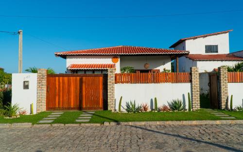 a house with a gate and a fence at Rosa dos Ventos em São Miguel do Gostoso in São Miguel do Gostoso