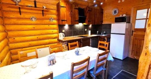 a dining room with a table and a kitchen at Ośrodek Wczasowy Na Borach in Korbielów