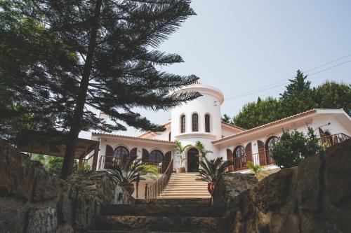 a large white house with a stone wall at Villa Pietra Estoril Eco Guesthouse in Estoril