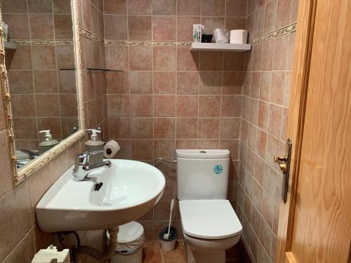 a bathroom with a sink and a toilet and a mirror at CASA JESUS in Abiego