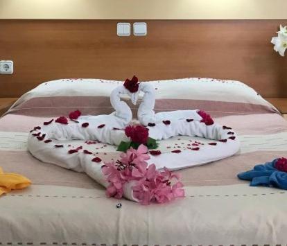 a bed with a cross on it with flowers on it at Turkuaz Bungalov in Fethiye