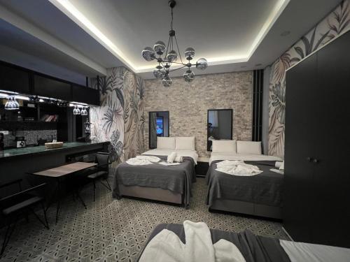 Mudem Boutique Hotel في إسطنبول: غرفة نوم بسريرين ومكتب وبيانو