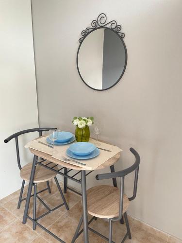 a table with two chairs and a mirror on the wall at Souzana Suite Leptokarya in Leptokarya
