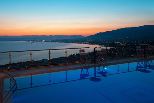 a balcony with chairs and a view of the water at Belvedere Hotel in Kalamata