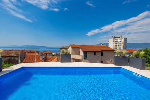 a large blue swimming pool on top of a house at Apartmants Belvedere Rijeka in Rijeka