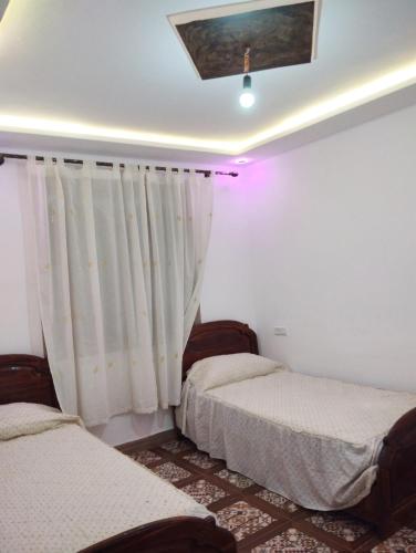 1 dormitorio con 2 camas y techo en Bab mahrouk, en Chefchaouen