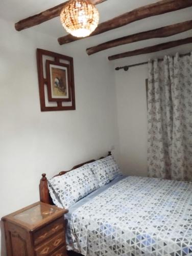 1 dormitorio con cama y lámpara de araña en Bab mahrouk, en Chefchaouen