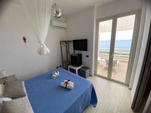 ein Schlafzimmer mit einem blauen Bett und einem großen Fenster in der Unterkunft Locazione Turistica Il Tucano in Agrigento