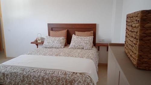 1 dormitorio con cama con cabecero de madera y almohadas en La Pedriza II en Enix