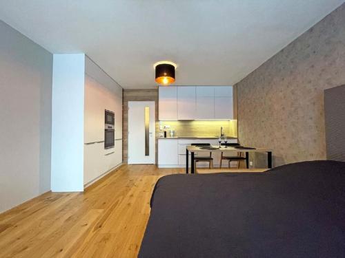 um quarto com uma cama e uma cozinha com uma mesa em Apartmán Harmonie - Šumava em Frischwinkel