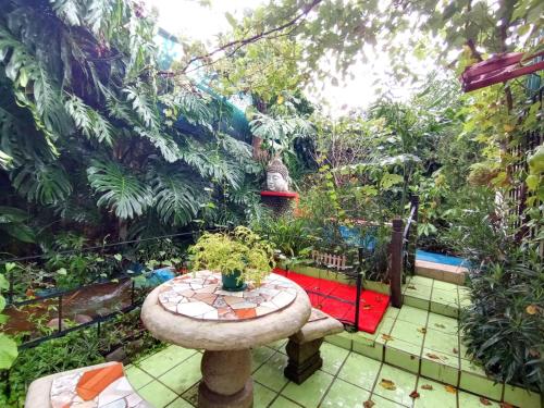 a small garden with a table in the middle at Nirvana Apartament Hostal in Alajuela City