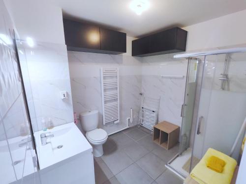 La salle de bains blanche est pourvue d'une douche et de toilettes. dans l'établissement Cozy Sunshine Apartment with Balcony 4 persons max, à Ivry-sur-Seine