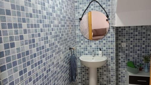 a blue tiled bathroom with a sink and a mirror at La Pedriza II in Enix