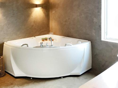 a white bath tub in a bathroom with a window at Holiday home Hvide Sande XXVI in Bjerregård