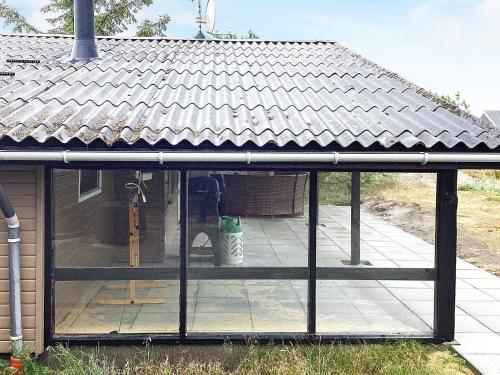 a screened in porch of a house with a roof at Dune Escape with Games and WiFi-By Traum in Bjerregård