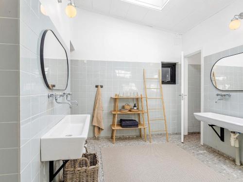Frederiksværkにある18 person holiday home in Frederiksværk-By Traumの洗面台と鏡のある白いバスルーム