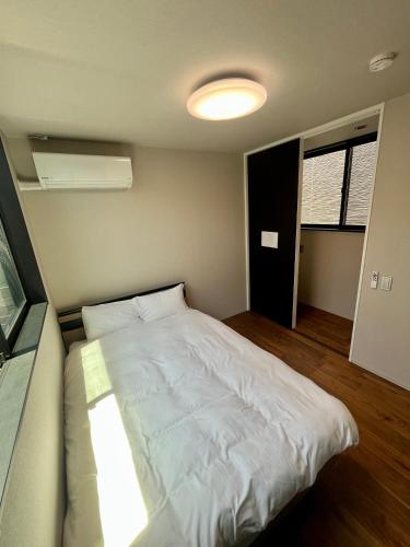 a bedroom with a white bed in a room at Flower Base Fuji in Muromimachi